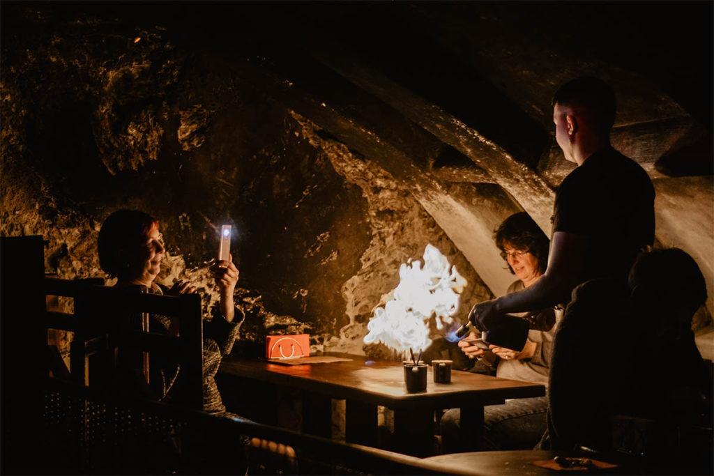 Osoba przy stole z ogniem na wycieczce z East Travel